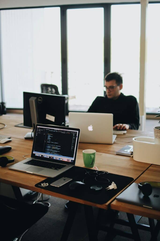 A young man sitting at a computer doing resume after being laid off.