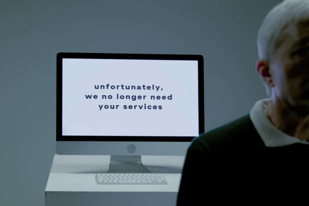 A computer screen displays a termination message, indicating job loss, layoffs, or being laid off or unemployment.