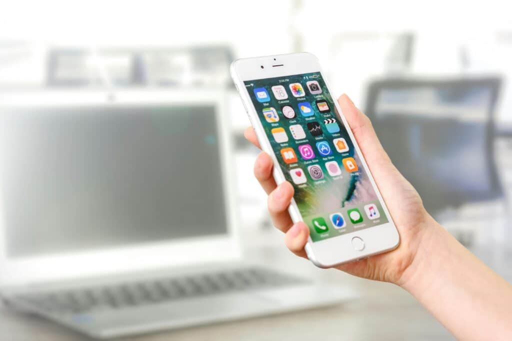 Close-up view of a smartphone displaying apps, held by a hand, ready to book an appointment with a therapist for entrepreneurs & buiness owners