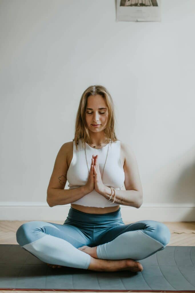 A serene image of a woman practicing meditation indoors, promoting mindfulness and wellbeing, which is a good way to learn how to be yourself