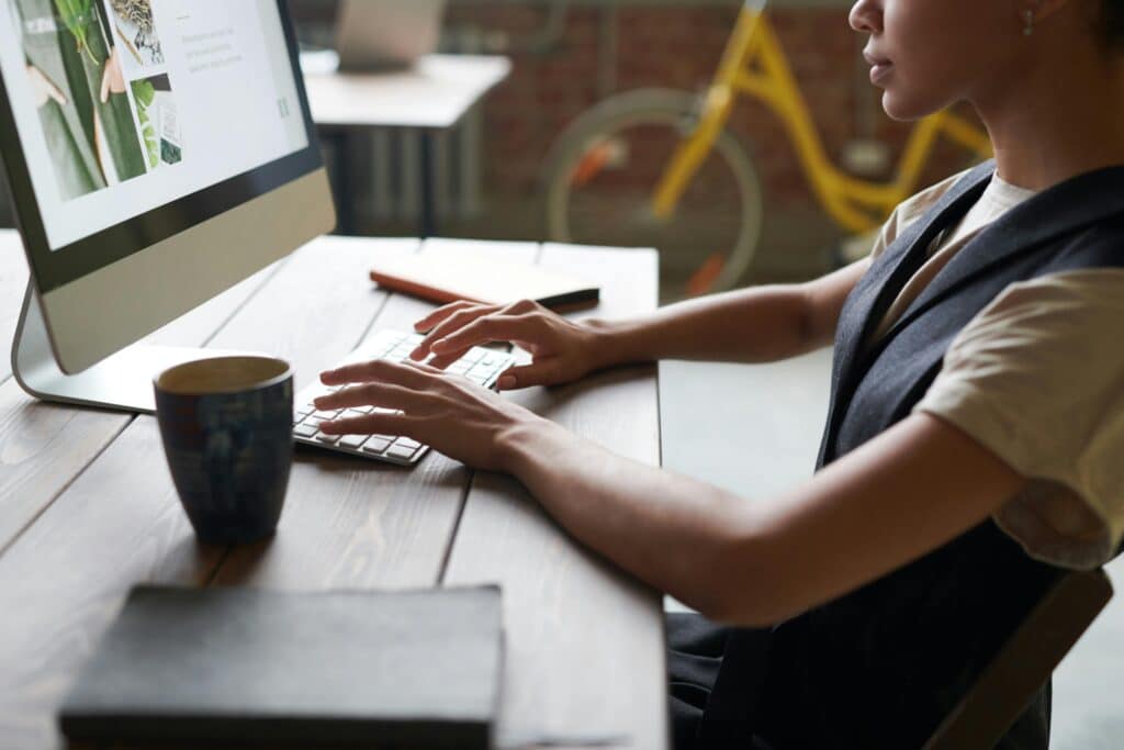 A professional adult working on a desktop computer at a modern office desk, promoting productivity.