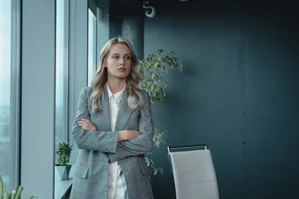 A professional businesswoman stands confidently in a modern office, exuding leadership and determination.