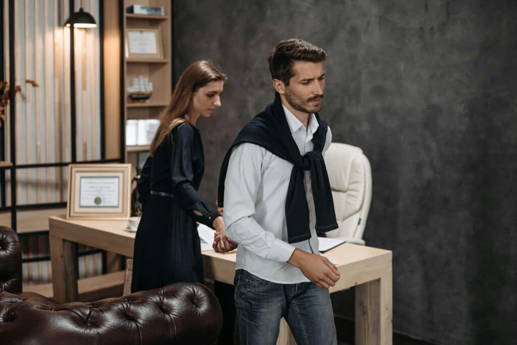 Fashionable couple in office with elegant decor, highlighting modern workplace dynamics.