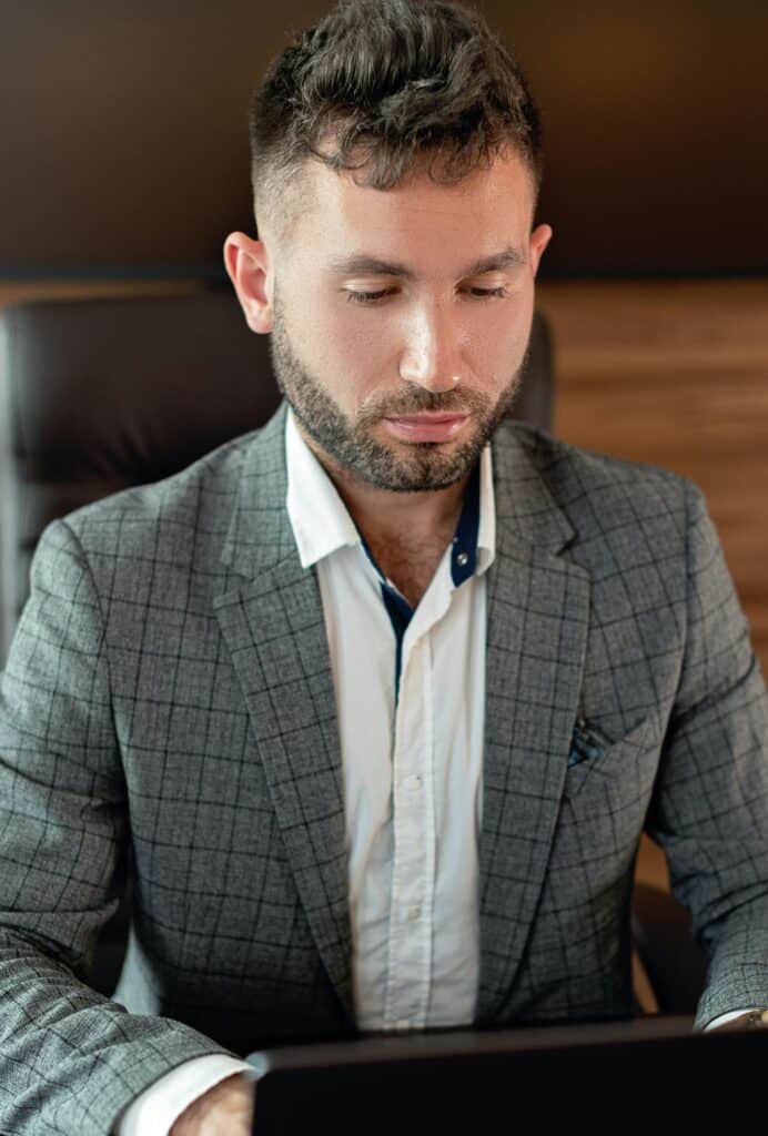 Businessman in a gray suit focused on work at an office desk.
